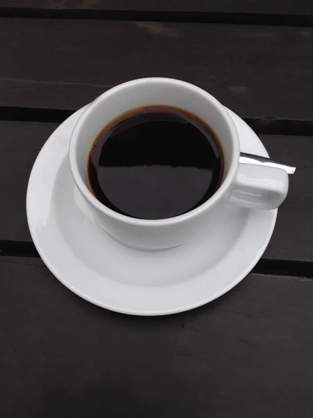 Kaffeetasse auf dem schwarzen Tisch — Stockfoto