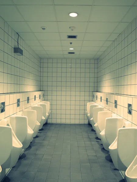 Biały WC z pisuaru wiersz w widoku perspektywicznym — Zdjęcie stockowe