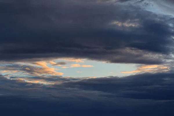 Stück klaren blauen Himmel umgeben von Gewitterwolken. Natur — Stockfoto