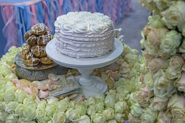 Hermoso pastel de bodas rodeado de rosas. Decoración — Foto de Stock