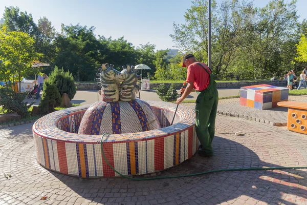 Київ, Україна - 27 серпня 2016: Чоловіки - cleaner очищає фонтан на ігровому майданчику — стокове фото