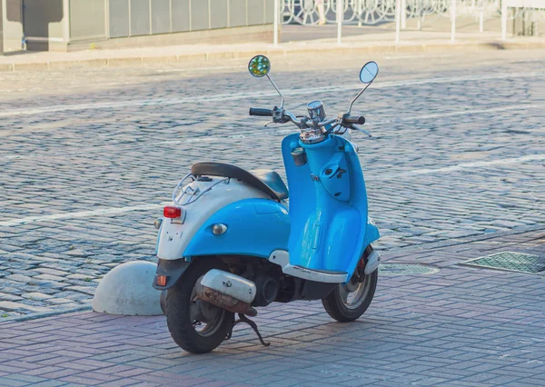 Блакитний скутер припаркований на узбіччі. Транспорт — стокове фото