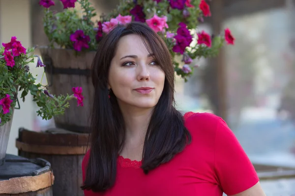 Güzel kadını bir çiçek yatakta kırmızı bir bluz. İnsanlar