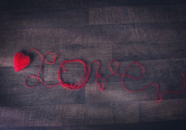Kalp ve metin şeklinde kırmızı clews geri ahşap üzerinde seviyorum