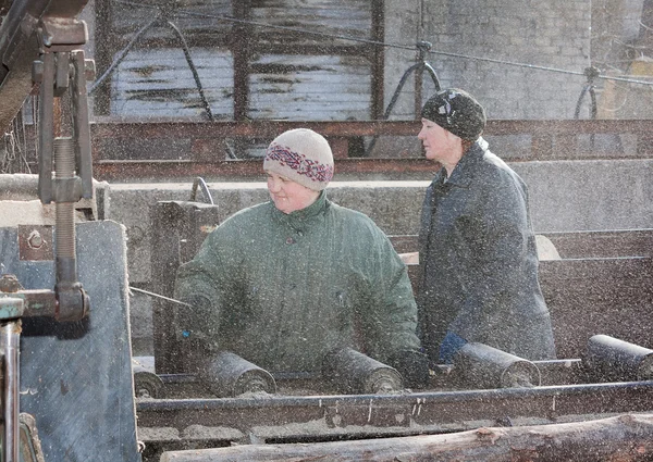 Donetsk, Ucrania - 20 de febrero de 2013: Las mujeres trabajan en el aserrado de madera — Foto de Stock