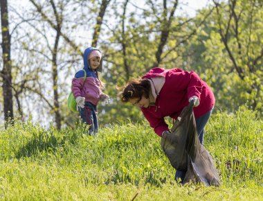 Zugres, Ukrayna - 26 Nisan 2014: Anne ve kızı şehir parkin şehir parkı temizlemek