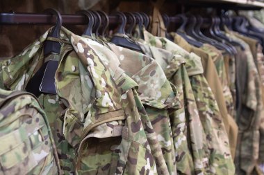 Samples camouflage military clothes in the store. Sale