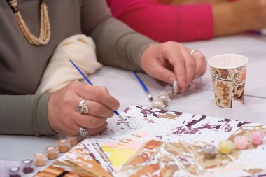 Woman's hand drawing on numbered canvas painting by numbers. Creative hobby