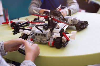 Çocuklar robotik dersinde model montajı üzerinde çalışıyorlar. Eğitim