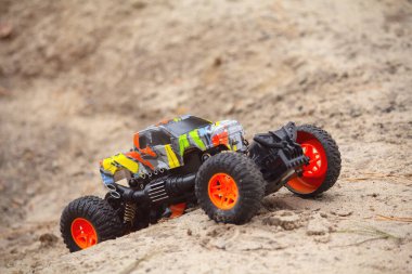 Gerçekçi RC off-road oyuncak arabası kuma yakın çekim tırmanıyor