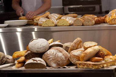 Fırında taze ekmek kesiyor. Yiyecek.