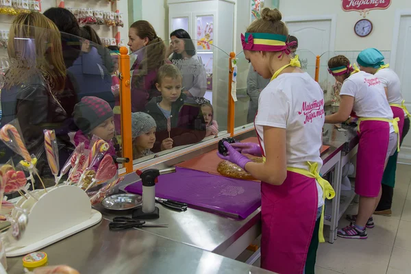 Івано-Франківськ, Україна-17 жовтня 2015: Діти дивитися майстрами на роботі в магазині студії для виробництва льодяникової карамелі — стокове фото