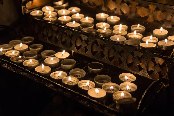 Las velas encendieron a los feligreses en la iglesia católica. Religión —  Fotos de Stock