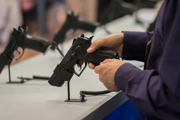 Uma arma na mão dele. Exposição e venda de armas — Fotografia de Stock