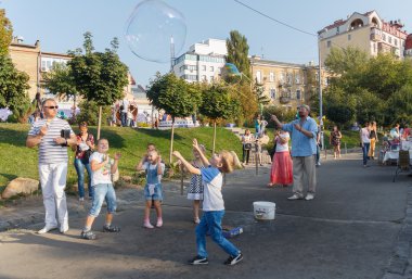 Kiev, Ukrayna - Sepnember 19, 2015:Man büyük kabarcıklar çalışan çocuk eğlendirir