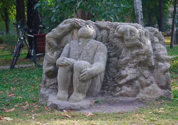 Стилізований кам'яні фігури людини, що сидить на землі. Київ, Україна — стокове фото