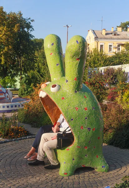 Kiev, Ucrania - 17 de septiembre de 2015: Pareja sentada en un banco en un personaje fantástico — Foto de Stock