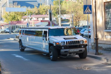 Kiev, Ukraine - October 03, 2015: Large and luxurious white limousine Hummer on city street clipart