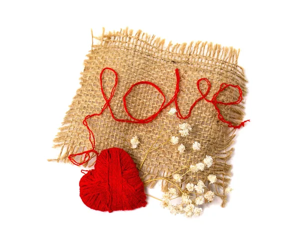 Heart of yarn in cloth and dried flowers isolated on white background — Stock Photo, Image