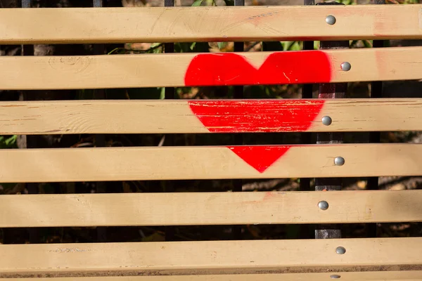 Czerwone serce namalowane na drewnianej ławce. Miłość — Zdjęcie stockowe