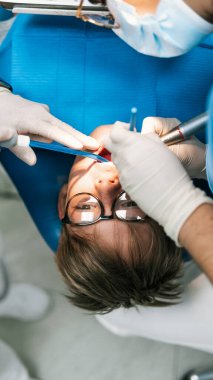 Tanımlanamayan profesyonel diş işçilerinin genç bir hastayla çekilmiş resmi..