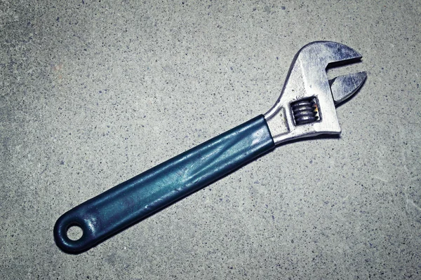 Adjustable wrench on a gray background