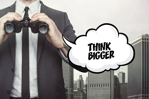 Think bigger text on speech bubble with businessman holding binoculars — Stock Photo, Image