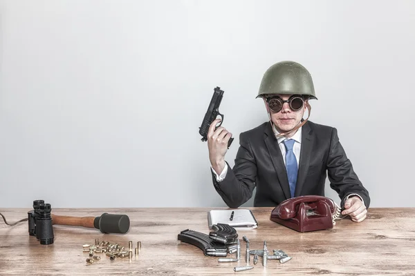 Vintage military businessman sitting at office desk with hand gun — Stock Photo, Image
