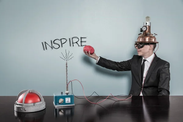 Inspirar concepto con empresario sosteniendo el cerebro — Foto de Stock