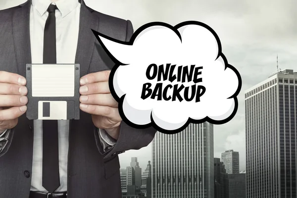 Texto de backup on-line na bolha de fala com empresário segurando disquete — Fotografia de Stock