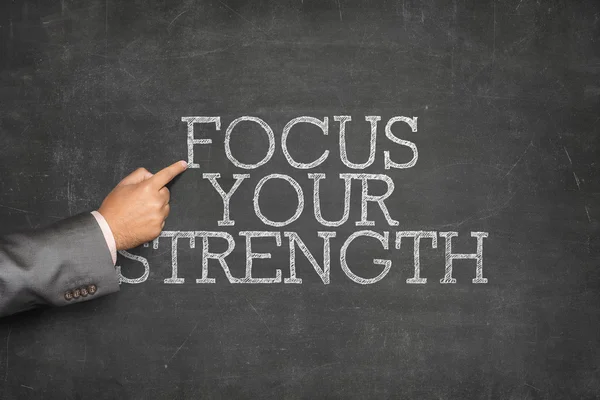 Focus Your Strength text on blackboard with businessman hand pointing — Stock Photo, Image