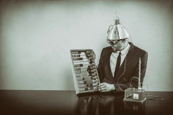 Businessman sitting at office desk with abacus — Stock Photo, Image