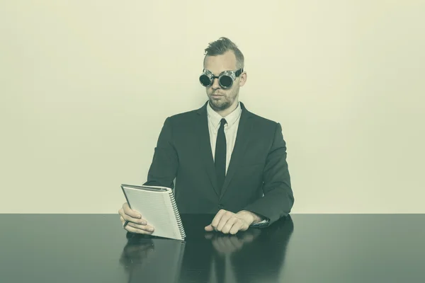 Geschäftsmann sitzt mit Notizblock am Schreibtisch — Stockfoto