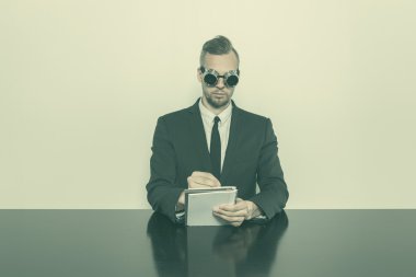 Not Defteri ile ofis masa başında oturan işadamı