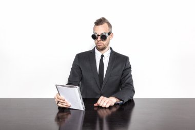 Not Defteri ile ofis masa başında oturan işadamı