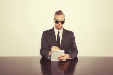 Not Defteri ile ofis masa başında oturan işadamı