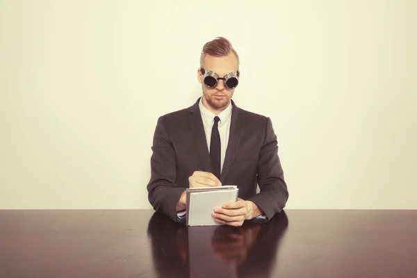 Zakenman achter bureau met Kladblok — Stockfoto