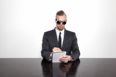 Not Defteri ile ofis masa başında oturan işadamı