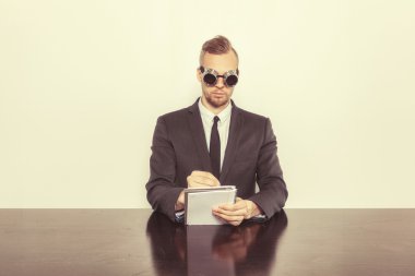 Not Defteri ile ofis masa başında oturan işadamı