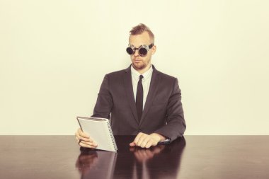 Not Defteri ile ofis masa başında oturan işadamı