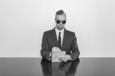 Not Defteri ile ofis masa başında oturan işadamı