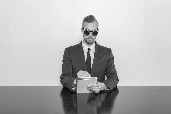 Uomo d'affari seduto alla scrivania dell'ufficio con blocco note — Foto Stock