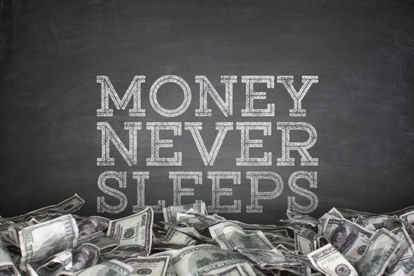 Χρήματα δεν κοιμάται ποτέ σε μαυροπίνακα φόντο — Φωτογραφία Αρχείου