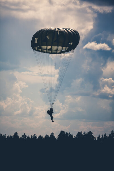 Parachutist in cloudy sky