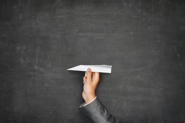 Blackboard em branco preto com mão segurando avião de papel — Fotografia de Stock