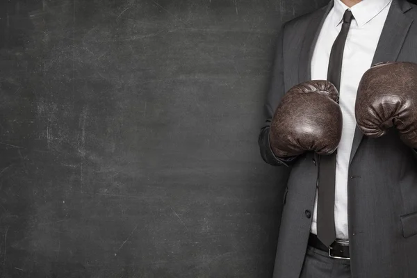 Affärsman i boxhandskar på blackboard bakgrund — Stockfoto