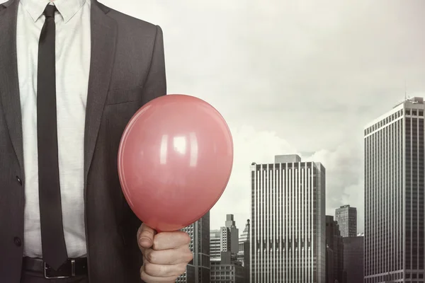 Affärsman med ballong i handen på stadsbilden bakgrund — Stockfoto