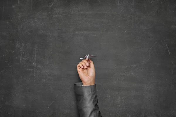 Zwarte leeg bord met hand die papier vliegtuig — Stockfoto