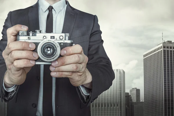 Uomo d'affari che scatta una foto con fotocamera vintage — Foto Stock