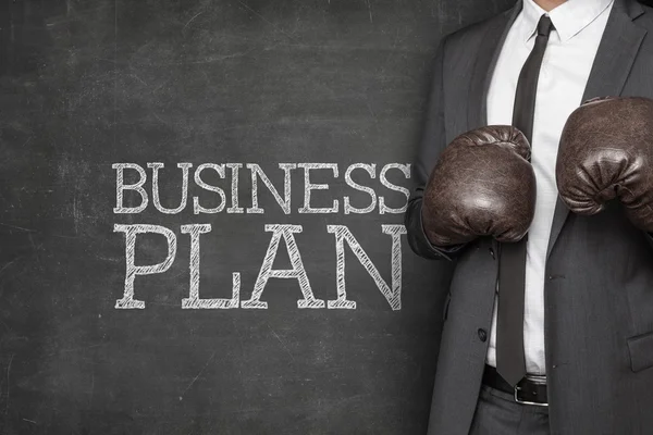 Business plan on blackboard with businessman — Stock Photo, Image